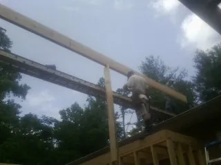 Carpenter setting a ridge beam over a new addition frame — Ice Dam Removal by Roofing Brothers in Dixon Springs