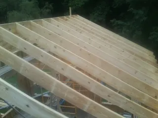 New roof rafters set over an addition before sheathing in Dixon Springs
