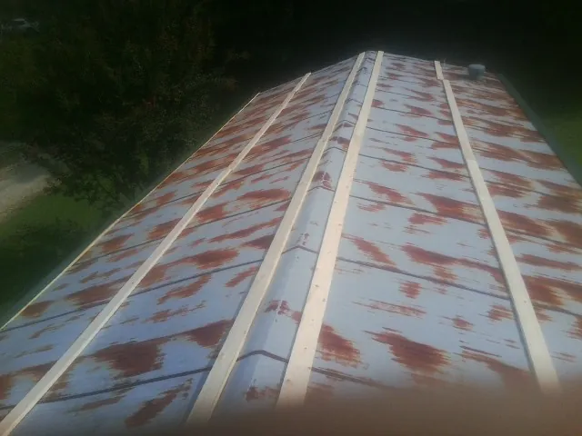 Rusted metal roof panels with new wood purlins before replacement — Storm Damage Roof Repair in Dixon Springs by Roofing Brothers