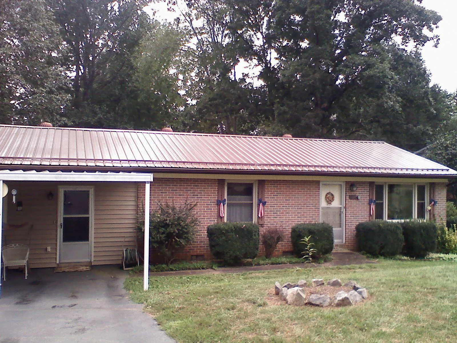 Bronze metal roof and carport on a brick ranch home — Roof Repair work by our crew in Dixon Springs