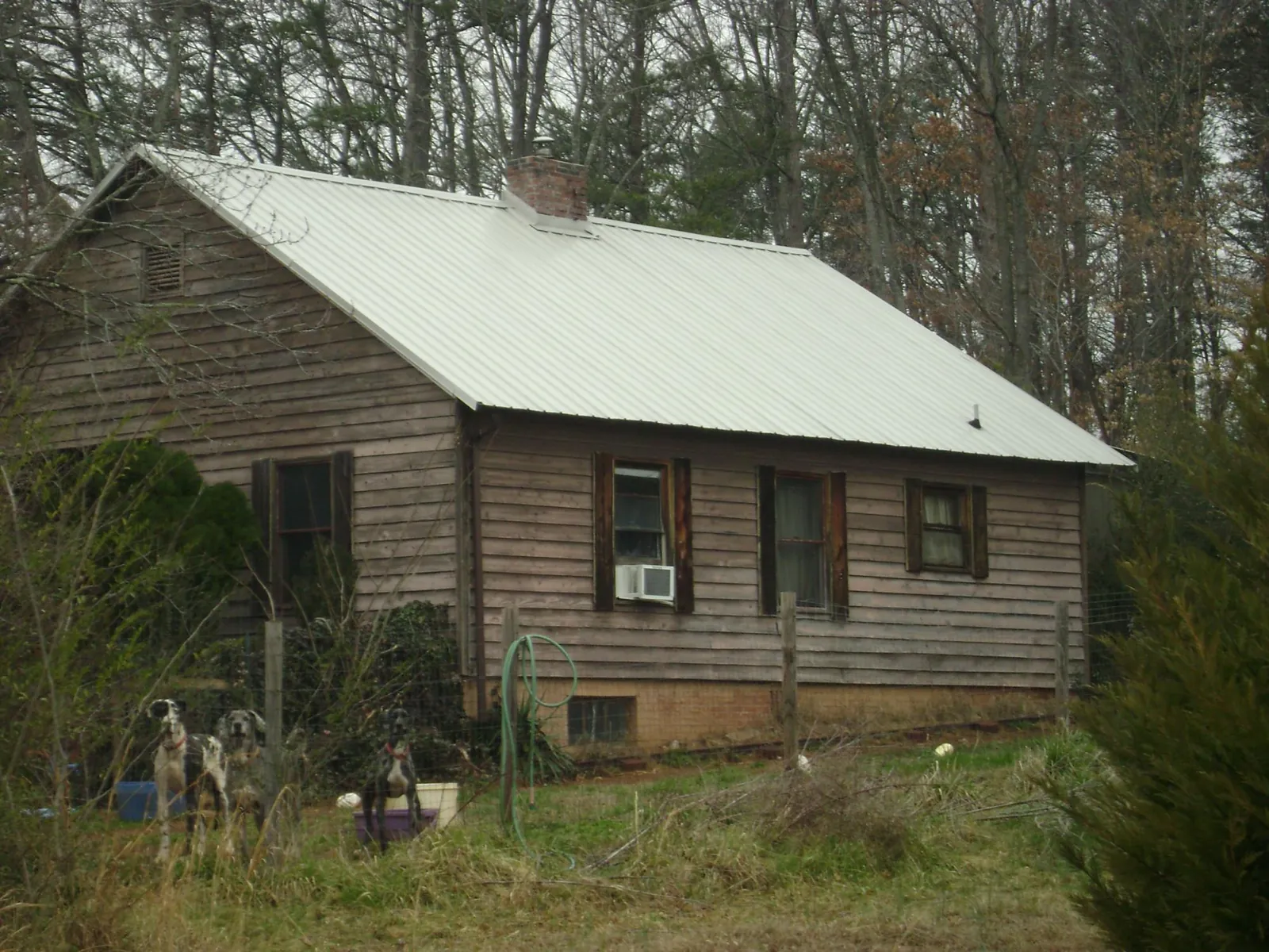 White metal roof on an old wood sided farmhouse, from a Metal Roof Installation job in Dixon Springs